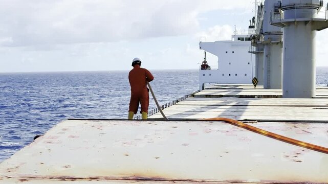 ship crew washing hatch covers use fire hose. funny, amusing situation at the end. 