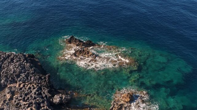 Mediterranean Sea coastline aerial video on Crete island, with waves splashing on rocks, above view
