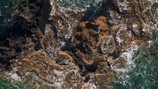 Mediterranean sea waves splashing on rocks, close-up aerial video on Crete Island coast
