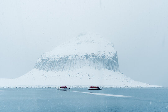 Edinburgh Hill basalt columns in Antarctica in snowy conditions with sea ice forming in the foreground