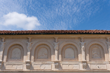 Ornate historic stone facade with terracotta roof against blue sky © Luigi