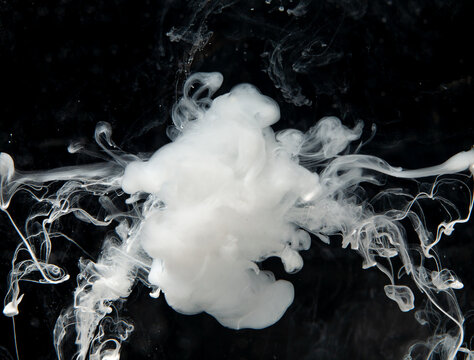 White smoke curls against a dark backdrop, forming unique shapes and patterns that slowly rise upwards
