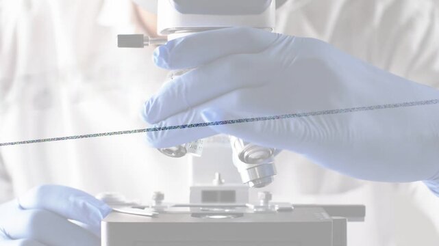 Male lab researcher placing slide then rotating microscope turret, selecting objectives for imaging