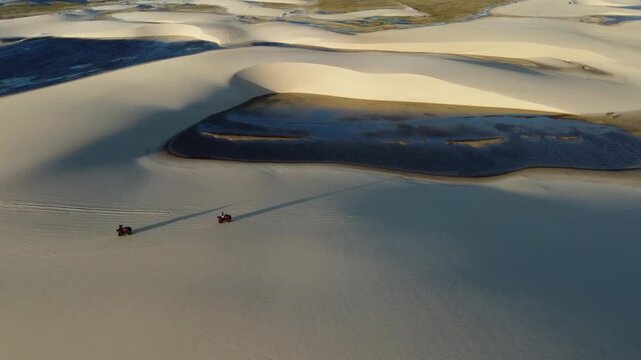 Drone shot from high above showing quad bikes in vast dunes, Lencois Maranhenses National Park