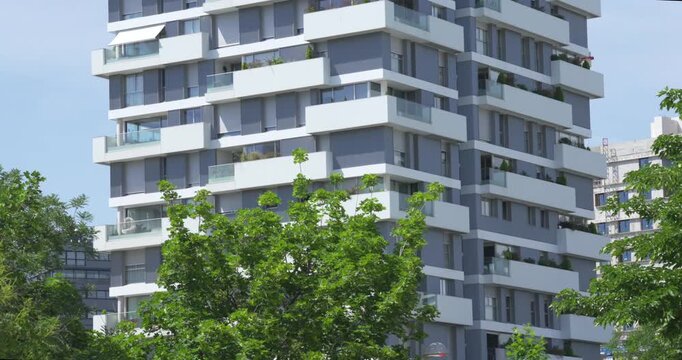 Modern residential apartment building with white layered balconies in Valdebebas, Madrid, Spain. Contemporary urban architecture on a sunny day