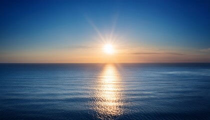 Obraz premium Serene Horizon With Subtle Sun Flare And Bokeh Over Tranquil Ocean Surface At Dawn