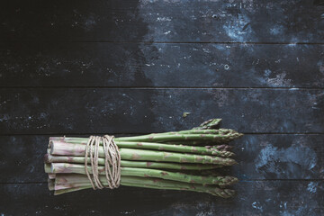 asparagi legati con lo spago su fondo scuro stile cinematic © Andrea