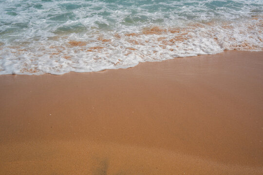 Sea foam washes over sandy beach on the Red Sea coast in Sharm El Sheikh Egypt with turquoise water and summer shoreline texture. Beach resort lifestyle and seaside tourism on the Red Sea
