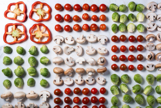 Composizione ordinata di verdure fresche disposte a griglia su sfondo chiaro