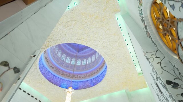 Stunning Islamic geometric patterns, gold leaf carvings, and majestic columns under glowing blue ambient lighting inside the Grand Mosque.