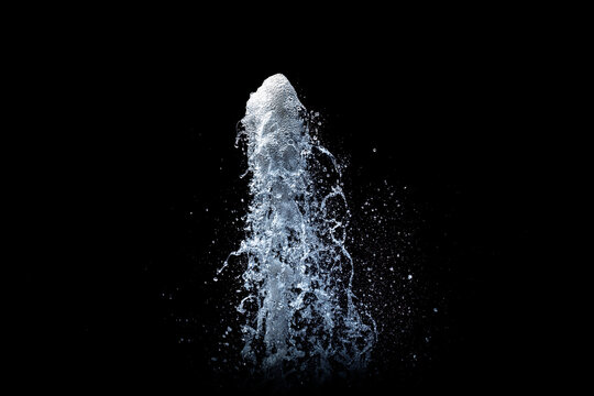 Water fountain shooting into the air with a black background, with copy space