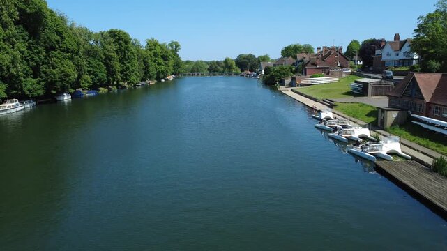 A view along The River Thames at Pangbourne in West Berkshire, England with blue sky, shot with a drone.