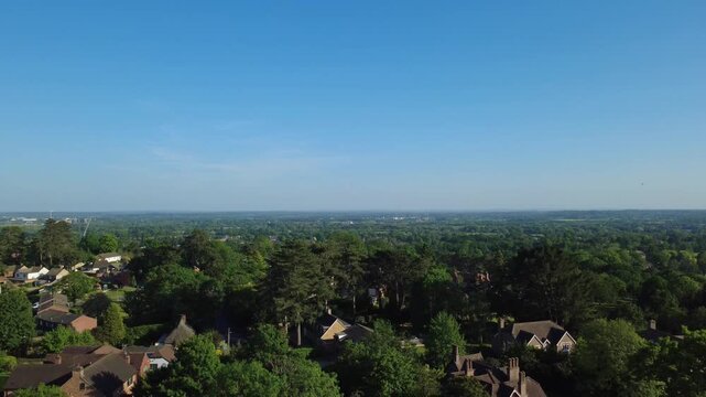 A descending drone shot taken from Routh Lane in the Tilehurst area of Reading, UK. Descending from above the tree line, back down to street level on Routh Lane