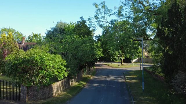 An ascending drone shot taken from Routh Lane in the Tilehurst area of Reading, UK. Ascending above the tree line, shows the green, leafy areas of Reading beyond