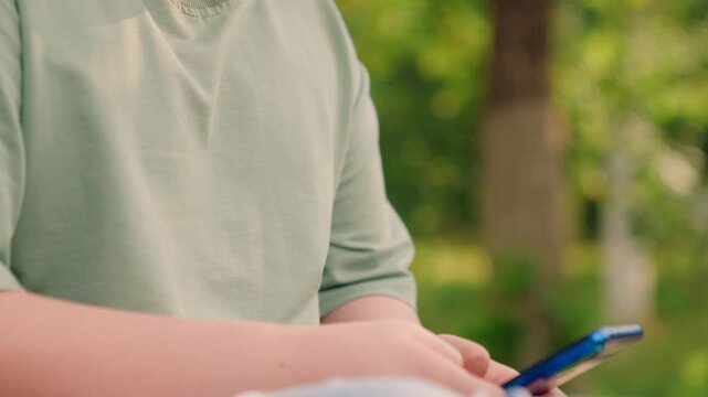 boy connecting to internet hotspot, concentrated boy plays adventure smartphone game online near pathway today., boy enjoys mobile internet game, boy checks internet leaderboard while playing