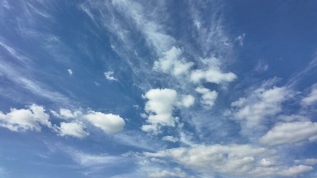 White clouds moving fast from right to left time-lapse. Daylight cloudy heaven background. Timelapse light clouds transforming in blue sky with motion blur. Blue sky. Perfect for text, titles, logo