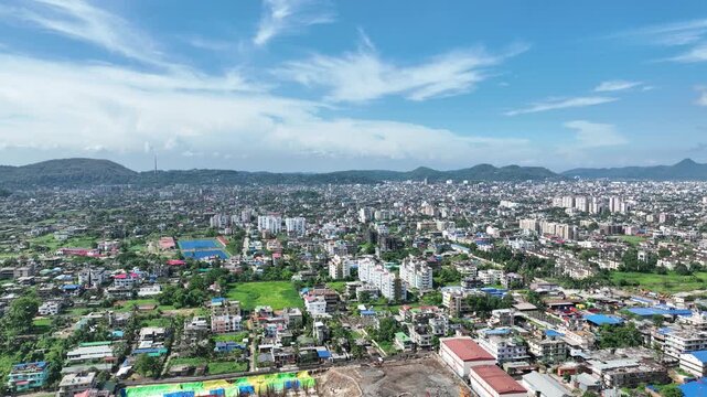 . An aerial drone shot captured a stunning panoramic view of Guwahati city, Assam india  showcasing its beauty against a picturesque sky and the adjacent splendor of Thaka Hill. 4k 