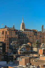 Obraz premium Empire State Building Rising Above Manhattan Rooftops at Golden Hour