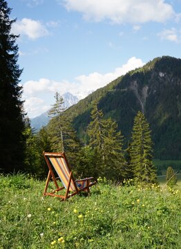 Lonely colorful reading chair in an alpine meadow in the Alps