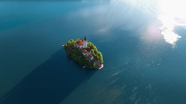 Aerial view of Bled Island and the Pilgrimage Church of the Assumption of Mary surrounded by the calm blue waters of Lake Bled in Bled, Radovljica, Slovenia.