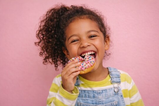 Joyful child enjoying colorful donut.