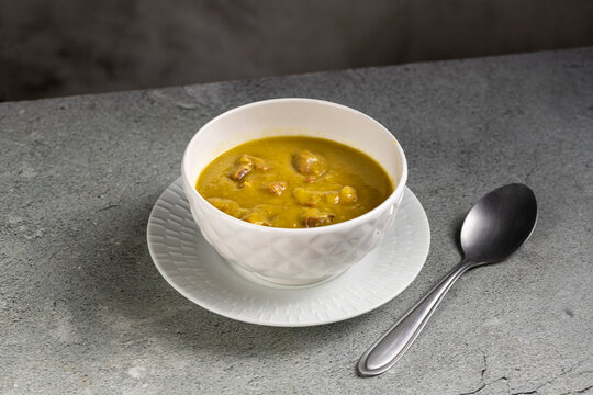 Homemade Split Pea Soup Served in White Bowl on Gray Table