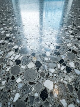 Macro polished architectural concrete surface exposed aggregate minerals grey texture material architecture close-up