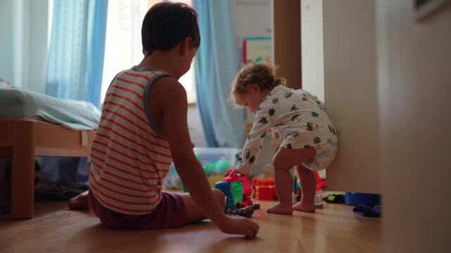 Brothers sitting on bedroom floor playing with toys in calm focused moment concept of imagination learning and sibling connection