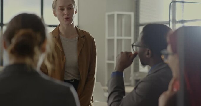Business person giving presentation to colleagues in office