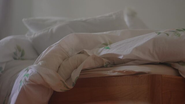 Messy unmade bed with rumpled duvet after playful sibling game in cozy family bedroom capturing authentic home atmosphere and carefree childhood energy