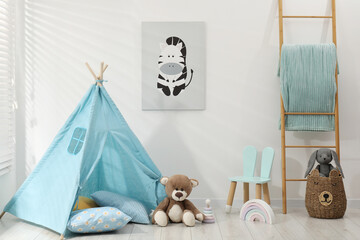 Wigwam, toys, small chair and pillows near white wall in child's room © New Africa