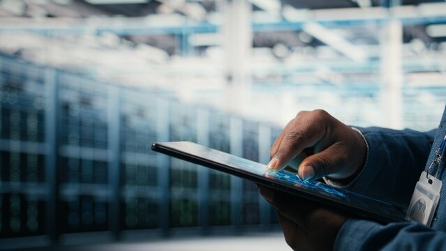 Close up of data center engineer using AI software on tablet to optimize performance and forecast issues, Programmer integrating artificial intelligence automation in data center operations, camera A.