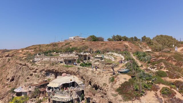 Aerial view of The Artistic House with cave structures and terraces carved into sandstone cliffs at Sidna Ali Beach in Herzliya, Israel
