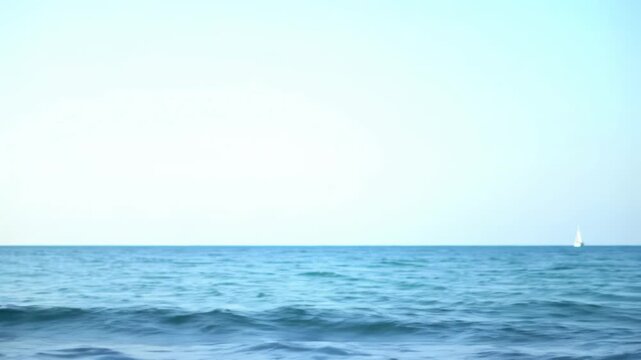 A wide, serene video of a vast deep blue ocean meeting an ethereal bright white sky, horizon low for copy space. Gentle waves break in crisp foreground water. Concept of limitless potential
