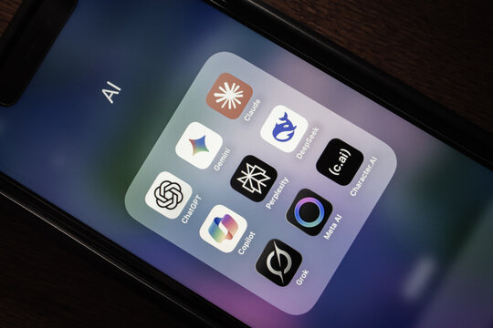 Quito, ECUADOR - Oct 13 2025 : Smartphone folder with popular AI assistant apps (ChatGPT, Gemini, Claude, Copilot, Perplexity, DeepSeek, Grok, Meta AI and Character.ai) are seen on iPhone screen.