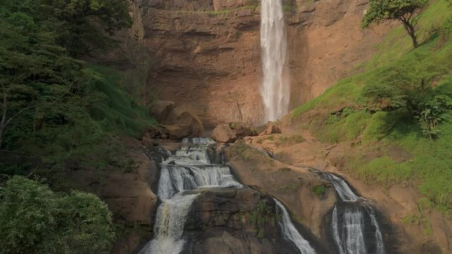 Aerial view of Cikanteh Waterfall cascading over rocky tiers surrounded by lush tropical greenery in Sukabumi, West Java, Indonesia.