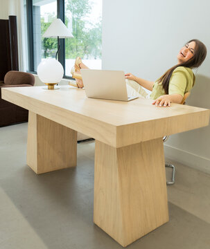 Woman Relaxing with Laptop in Modern Office Interior