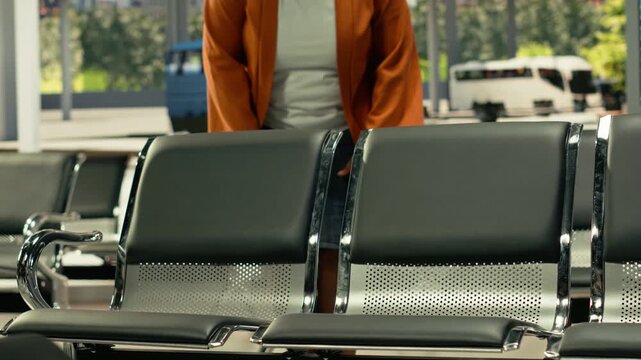 Passengers seated in bus terminal with backpacks and waiting for intercity coach, starting conversation with strangers and having a laugh before long-distance cross-country journey. Highway bus.