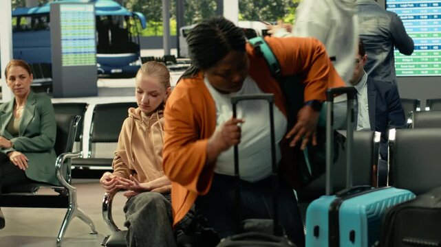 Scandal and conflict in bus station with two women fighting over seats, travel fatigue and rude behavior with passengers waiting on their intercity long-haul journey for relocation. Drama.