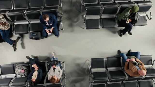 Sitting on empty seats, airport and travelers in terminal. Navigating air transportation hub, top down view shot and passengers with trolleys and boarding passes during international transit