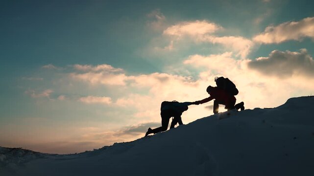 Travelers climb one after another on rock Climbers silhouettes stretch their hands to each other climbing to top of hill. Teamwork of business people. Go towards your goal. Team of businessmen victory