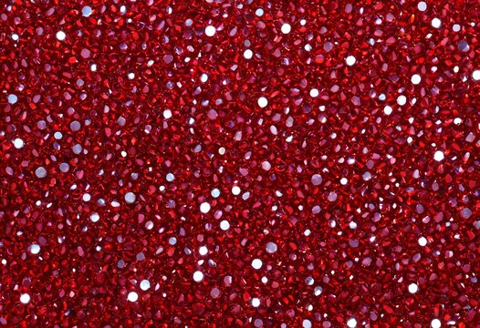 Background of closely packed red rhinestones and sparkling glitter