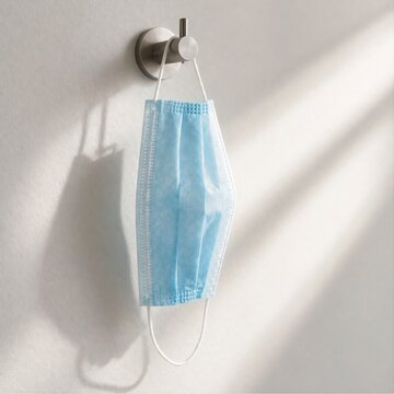  Blue Surgical Face Mask Hanging On Wall With Soft Sunlight Shadow, Healthcare Safety Concept