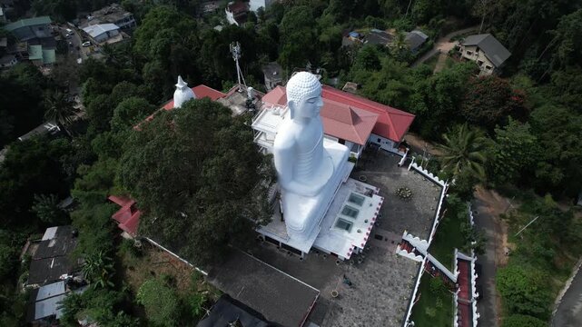 Aerial drone footage of the great Buddha Sri Maha Bodhi Viharaya in the city of Kandy, Sri Lanka, on a sunny day, 4k 30fps, 1 inch sensor