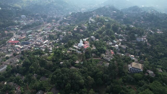 Aerial drone footage of the great Buddha Sri Maha Bodhi Viharaya in the city of Kandy, Sri Lanka, on a sunny day, 4k 30fps, 1 inch sensor