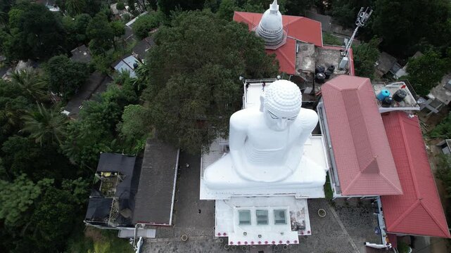 Aerial drone footage of the great Buddha Sri Maha Bodhi Viharaya in the city of Kandy, Sri Lanka, on a sunny day, 4k 30fps, 1 inch sensor