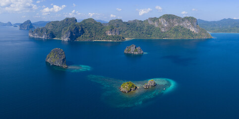 Surrounded by coral, rugged limestone islands rise from Bacuit Bay, El Nido. This area in the Philippines is a popular vacation destination due to its coral reefs, beaches, and limestone islands. © ead72