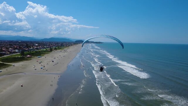 Powered Paraglider Flying Along a Tropical Beach