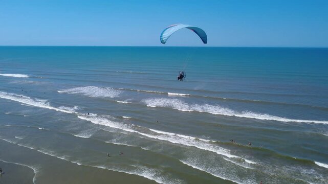 Powered Paraglider Flying Along a Tropical Beach