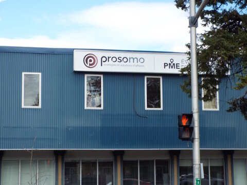 Gatineau, Quebec, Canada &ndash; May 1, 2026: A blue corrugated metal building features signage for "Prosomo, strat&eacute;gies et solutions d'affaires" on Boul. St-Joseph.